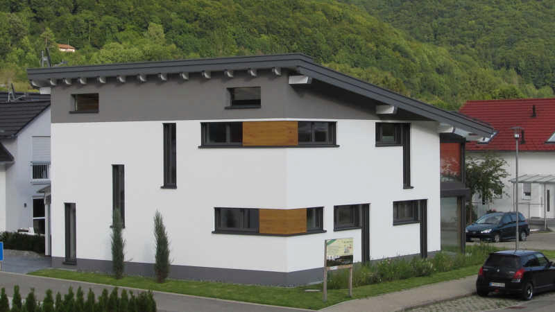 Modernes weißes Haus mit kubischer Form und Fensterbändern, Straßen-/Eckansicht.